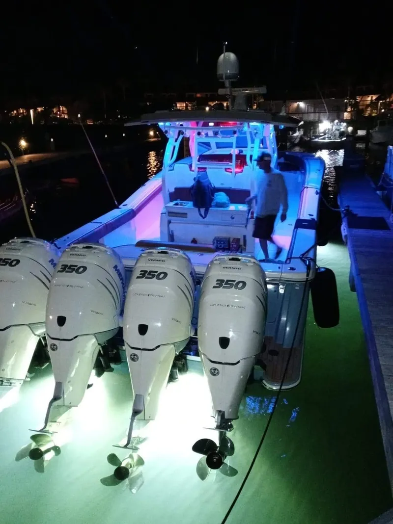 Slide: The Image of 2018 Scout 380 LXF boat with quad 350 Verado engines illuminated at night. - 8