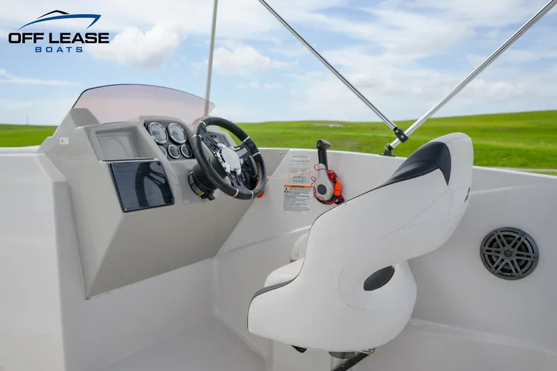 Slide: The Image of 2022 Starcraft SVX 231 OB boat cockpit with steering wheel and captain's chair. - 15