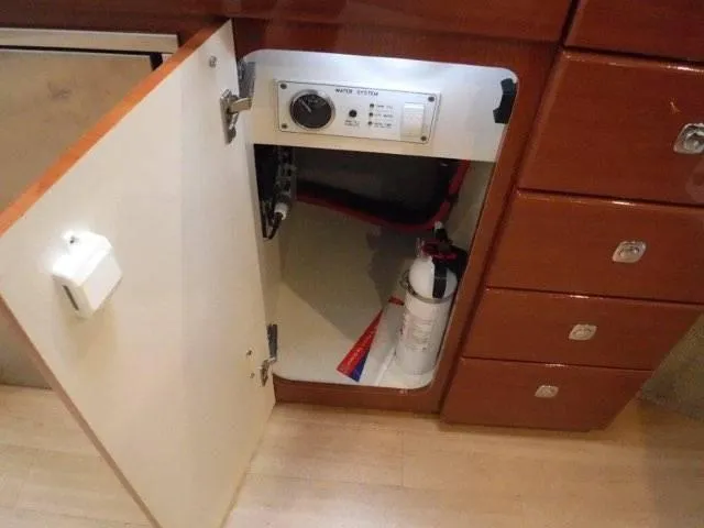Slide: The Image of Open cabinet in 2012 Formula 34 Cruiser with fire extinguisher and water system controls. - 23