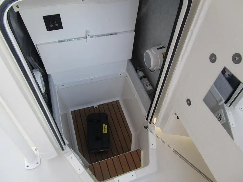 Slide: The Image of 2024 Ranger 2660 Bay boat storage compartment with wooden flooring and equipment. - 24