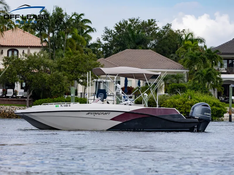 Slide: The Image of 2021 Starcraft SVX 231 OB boat on water near waterfront homes. - 2