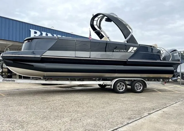 The Image of 2024 Sylvan M3 DLZ pontoon boat on a trailer outside a dealership. - 1