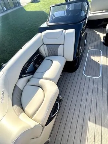 Slide: The Image of 2024 Sylvan M3 DLZ boat interior with beige seating and wood flooring. - 10