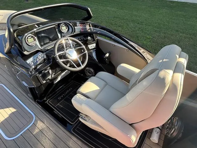 Slide: The Image of 2024 Sylvan M3 DLZ boat cockpit with modern steering wheel and comfortable captain's chair. - 21