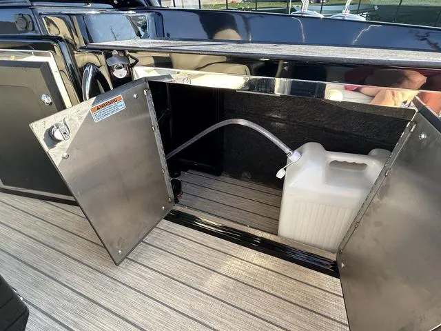 Slide: The Image of Open storage compartment on 2024 Sylvan M3 DLZ boat with water container. - 33
