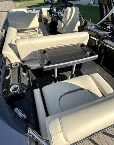 Slide: The Image of 2024 Sylvan M3 DLZ boat interior with beige seating and a central table. - 46