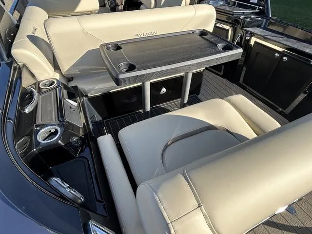 Slide: The Image of 2024 Sylvan M3 DLZ boat interior with beige seating and table. - 47