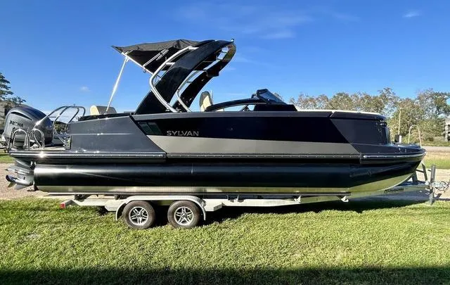 Slide: The Image of 2024 Sylvan M3 DLZ pontoon boat on a trailer, side view. - 6