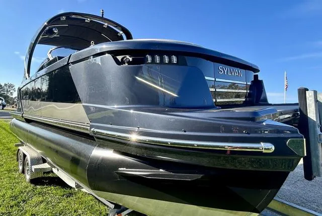 Slide: The Image of 2024 Sylvan M3 DLZ pontoon boat on trailer, side view. - 7