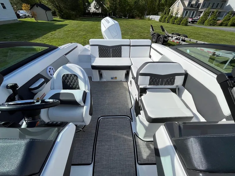Slide: The Image of 2024 Monterey M-205 boat interior with white and black seating, steering wheel, and spacious layout. - 17