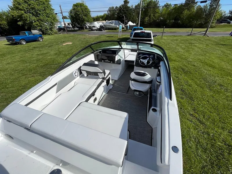 Slide: The Image of 2024 Monterey M-205 boat interior with white seating and steering wheel on grassy area. - 6