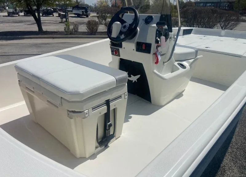 Slide: The Image of 2024 Mako Pro Skiff 17 CC center console boat interior with seating and steering wheel. - 2