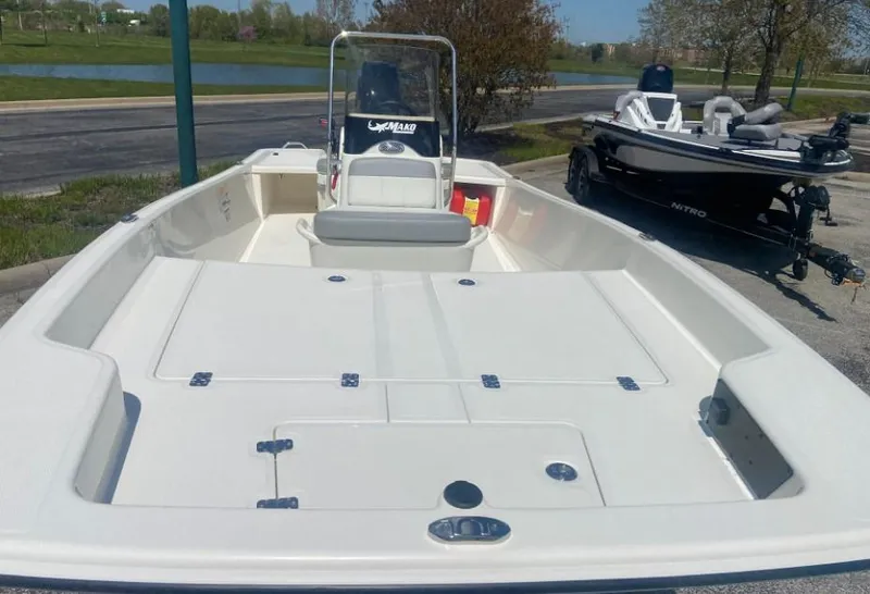 Slide: The Image of 2024 Mako Pro Skiff 17 CC boat, front view, parked near a lake. - 3