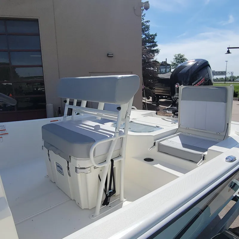 Slide: The Image of 2024 Mako Pro Skiff 19 CC boat interior with seating and storage compartments. - 5