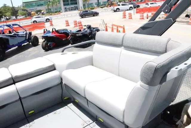 Slide: The Image of 2024 Sea-Doo Switch® Cruise 18 interior with comfortable seating, parked near vehicles. - 14