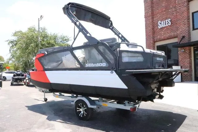 Slide: The Image of 2024 Sea-Doo Switch® Cruise 18 - 230 hp Galvanized boat on trailer outside sales building. - 4