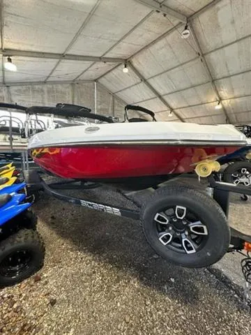 The Image of 2023 Scarab 165 ID boat in a storage facility, red hull, on a trailer. - 1