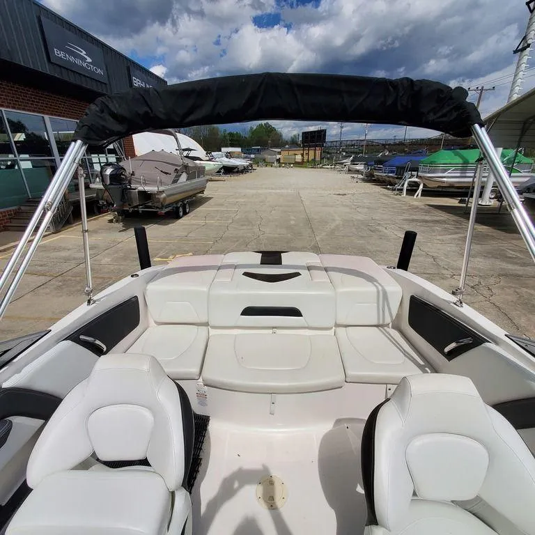 Slide: The Image of 2014 Chaparral 21 Sport boat interior with white seating and bimini top. - 3