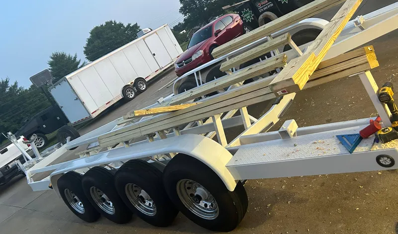 Slide: The Image of 2009 Formula 400 Super Sport boat trailer with triple axles in a parking lot. - 30