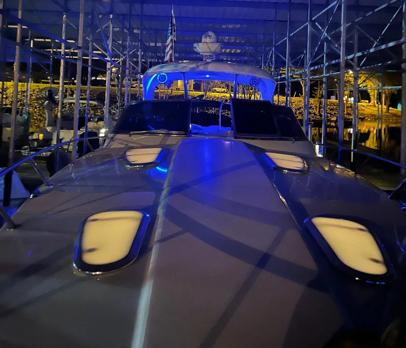 Slide: The Image of 2009 Formula 400 Super Sport yacht docked under blue lights at night. - 8