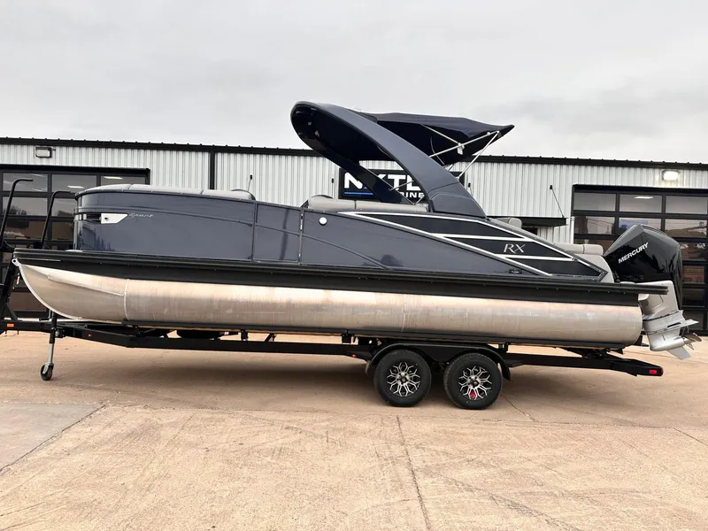 Slide: The Image of 2024 Bennington 23 RXSBA pontoon boat on trailer, sleek design, Mercury engine. - 1