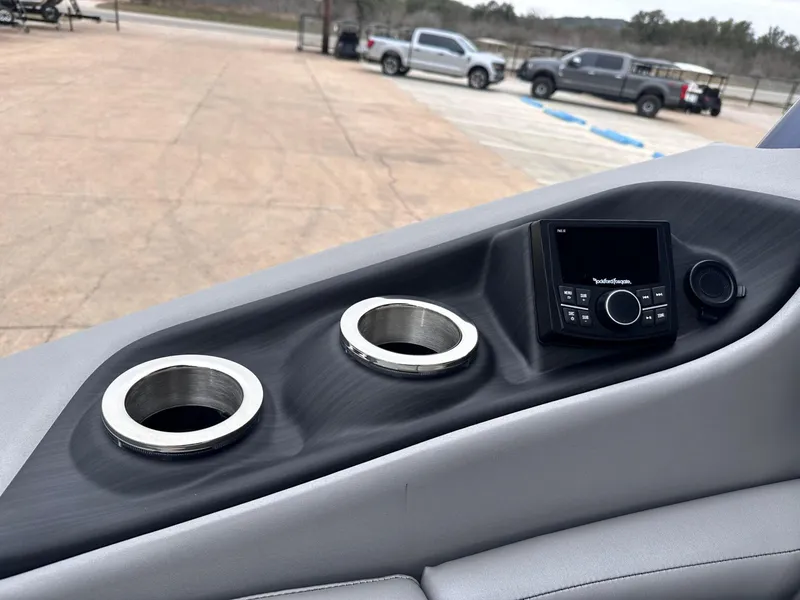 Slide: The Image of 2024 Bennington 23 RXSBA boat console with cup holders and audio controls. - 17
