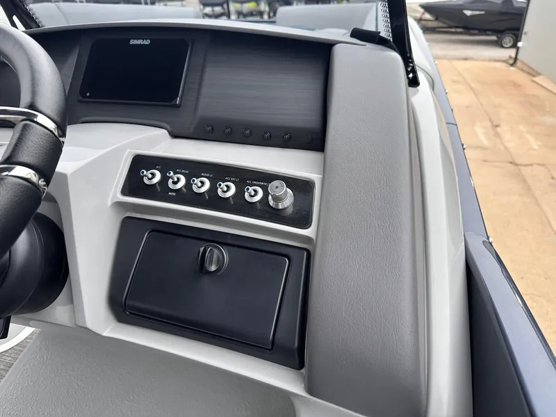Slide: The Image of 2024 Bennington 23 RXSBA boat dashboard with control panel and Simrad display. - 25