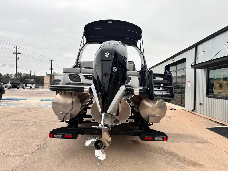 Slide: The Image of 2024 Bennington 23 RXSBA pontoon boat with powerful outboard motor, parked outdoors. - 4