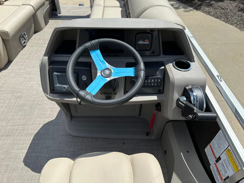 Slide: The Image of 2024 Sun Tracker SportFish 22 DLX boat helm with steering wheel and control panel. - 6