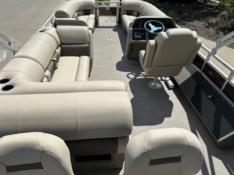 Slide: The Image of 2024 Sun Tracker SportFish 22 DLX pontoon boat interior with beige seating and captain's chair. - 9
