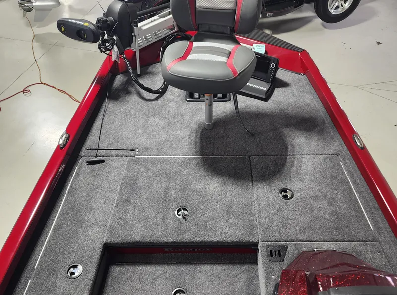 Slide: The Image of 2024 Ranger RT178 boat interior with gray carpet and red accents. - 6