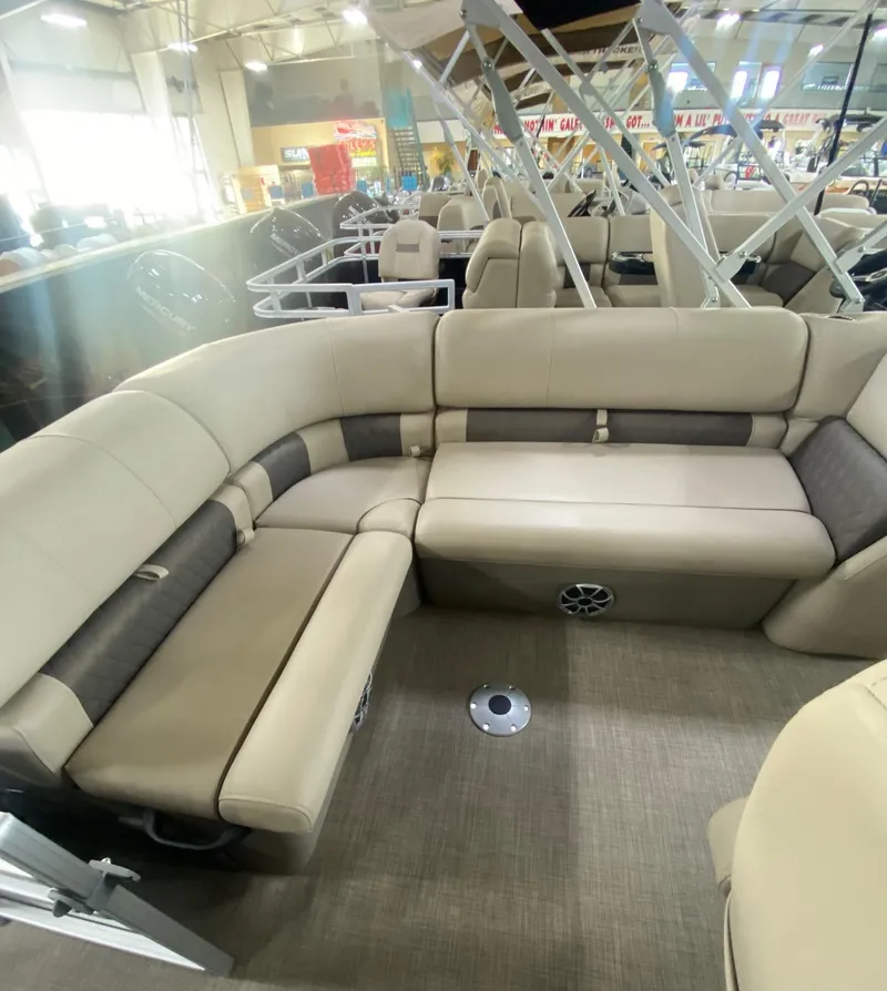 Slide: The Image of 2024 Sun Tracker Party Barge 20 DLX interior with beige seating and spacious layout. - 6
