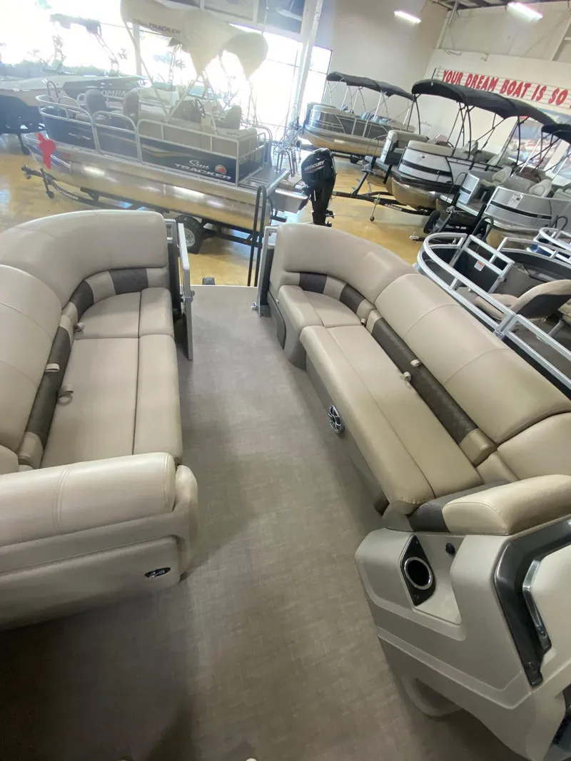 Slide: The Image of 2024 Sun Tracker Party Barge 20 DLX interior with spacious seating in showroom. - 7