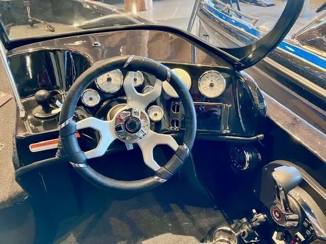 Slide: The Image of 2024 Nitro ZV19 Sport Pro boat dashboard with steering wheel and gauges. - 3