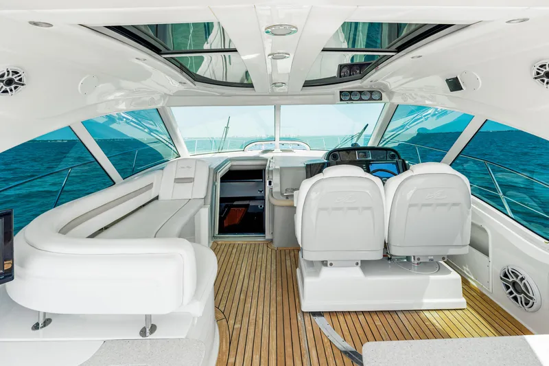 Slide: The Image of Interior of 2010 Sea Ray 500 Sundancer yacht with white seating and wooden flooring. - 39