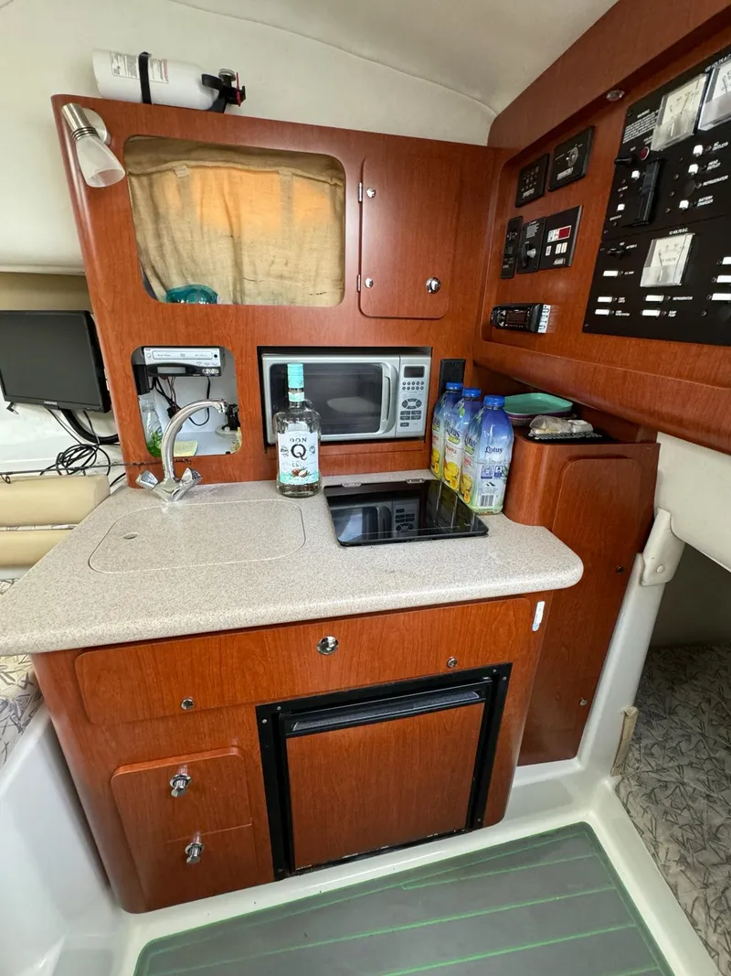 Slide: The Image of 2006 Pro-Line 32 Express boat kitchen with microwave, sink, and control panel. - 10