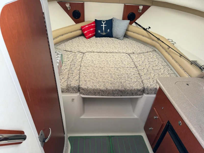 Slide: The Image of 2006 Pro-Line 32 Express cabin interior with bed, pillows, and kitchenette. - 7