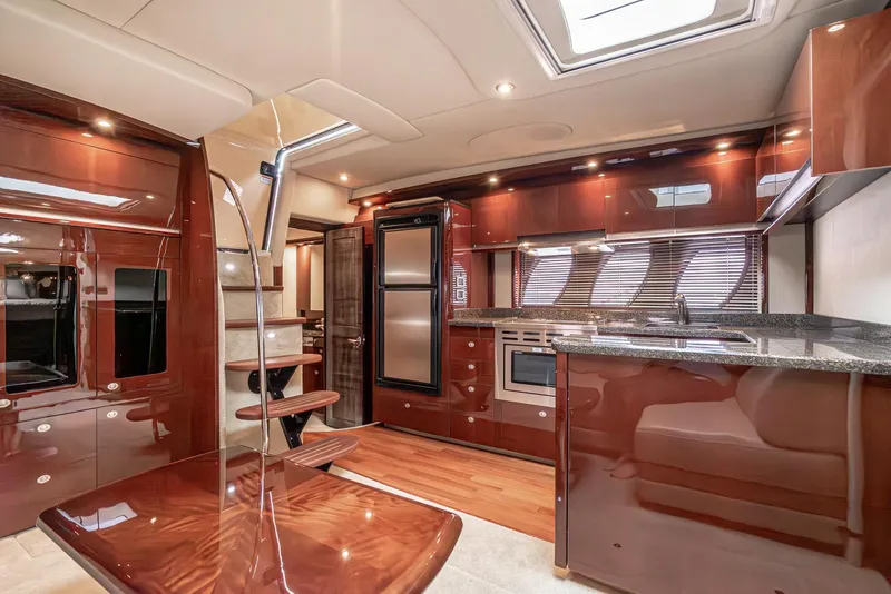 Slide: The Image of Luxurious interior of 2007 Sea Ray 48 Sundancer yacht with modern kitchen and wooden finishes. - 32