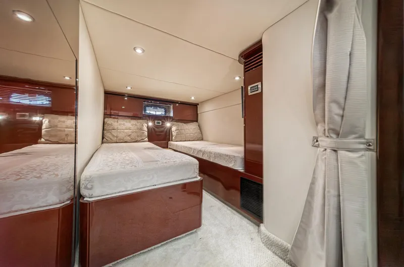 Slide: The Image of 2007 Sea Ray 48 Sundancer cabin with twin beds, elegant wood finish, and soft lighting. - 40