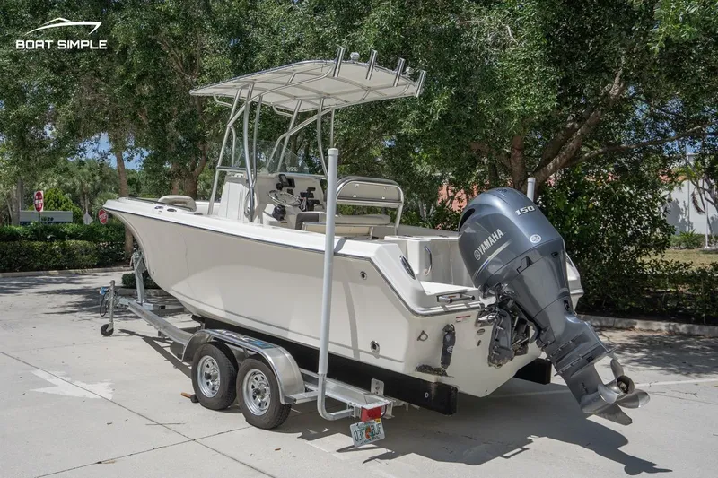 Slide: The Image of 2023 Sailfish 220 CC boat on trailer with Yamaha outboard motor, parked outdoors. - 2