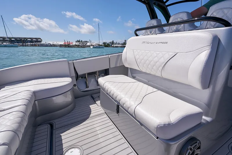Slide: The Image of 2020 Midnight Express 37' Open boat with luxurious white seating on a sunny day. - 14