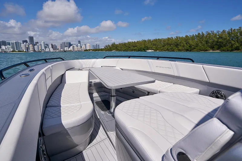 Slide: The Image of 2020 Midnight Express 37' Open boat with luxurious seating and table, city skyline in background. - 9