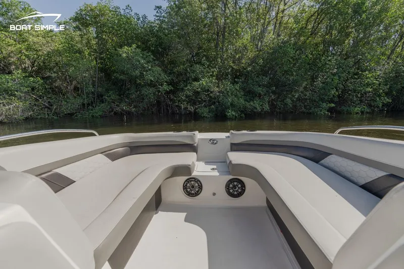 Slide: The Image of 2022 Hurricane 217 SD boat interior with spacious seating and lush greenery background. - 5