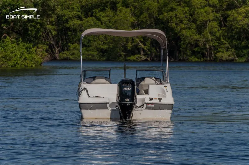 Slide: The Image of 2022 Hurricane 217 SD boat on calm water with canopy and outboard motor. - 3