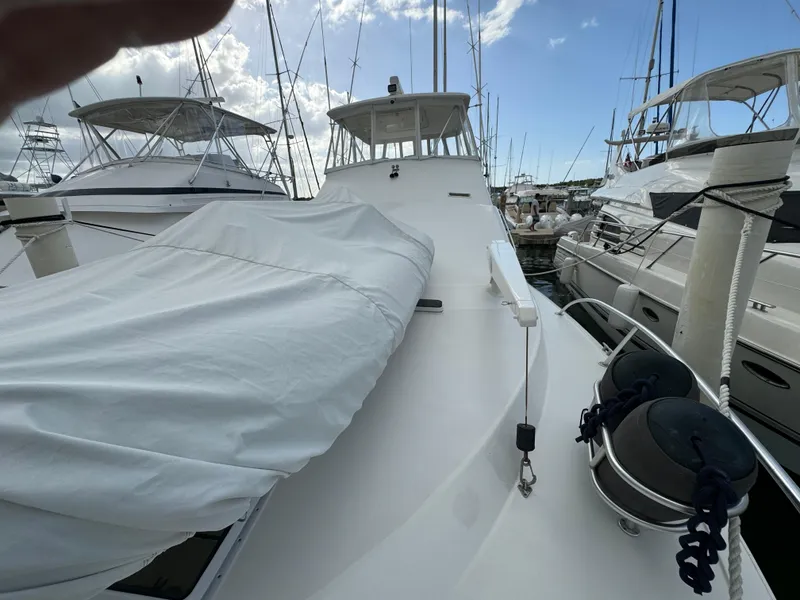 Slide: The Image of 2001 Ocean Yachts 48 docked, covered deck, surrounded by other boats under a blue sky. - 9