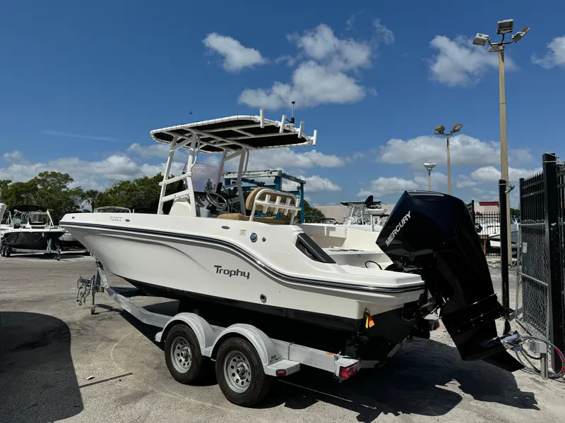 Slide: The Image of 2021 Bayliner Trophy T22CC boat on a trailer in a marina. - 2