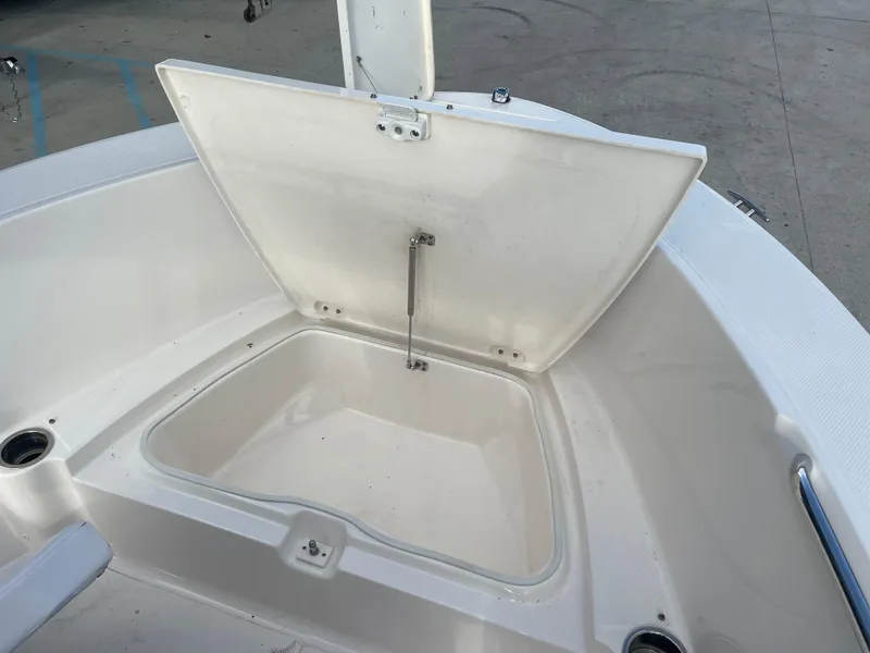 Slide: The Image of 2021 Robalo R180 Center Console storage compartment with open lid. - 10