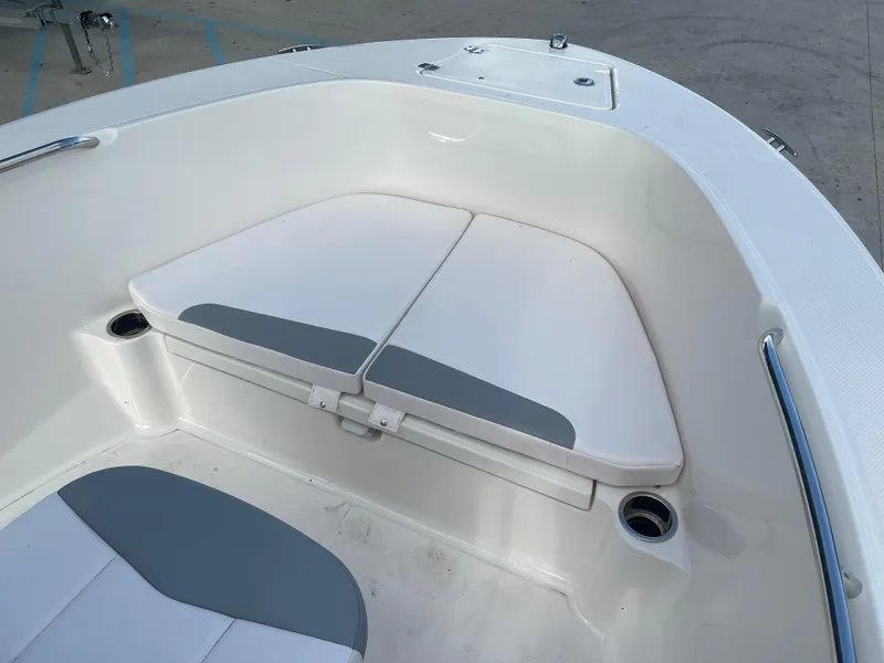Slide: The Image of 2021 Robalo R180 Center Console boat bow seating area with storage compartments. - 11
