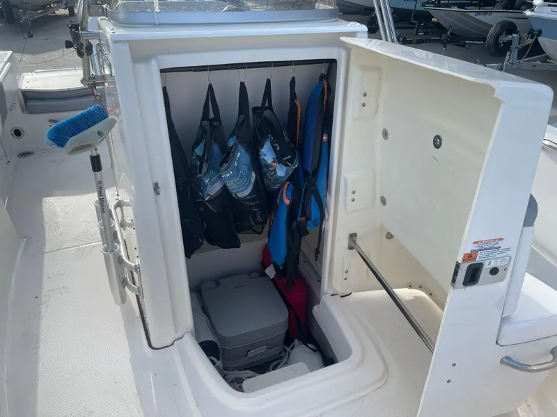Slide: The Image of 2021 Robalo R180 Center Console storage compartment with life jackets and equipment. - 13