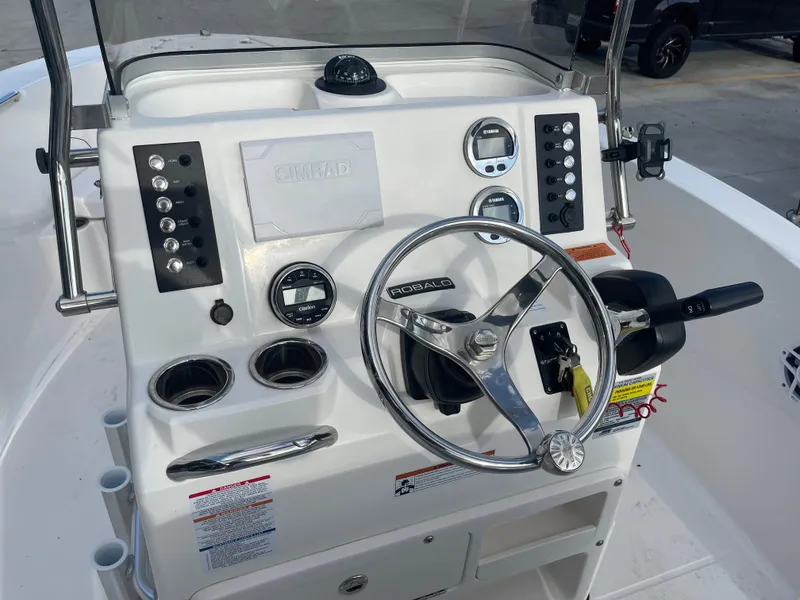 Slide: The Image of 2021 Robalo R180 Center Console boat dashboard with steering wheel and controls. - 16